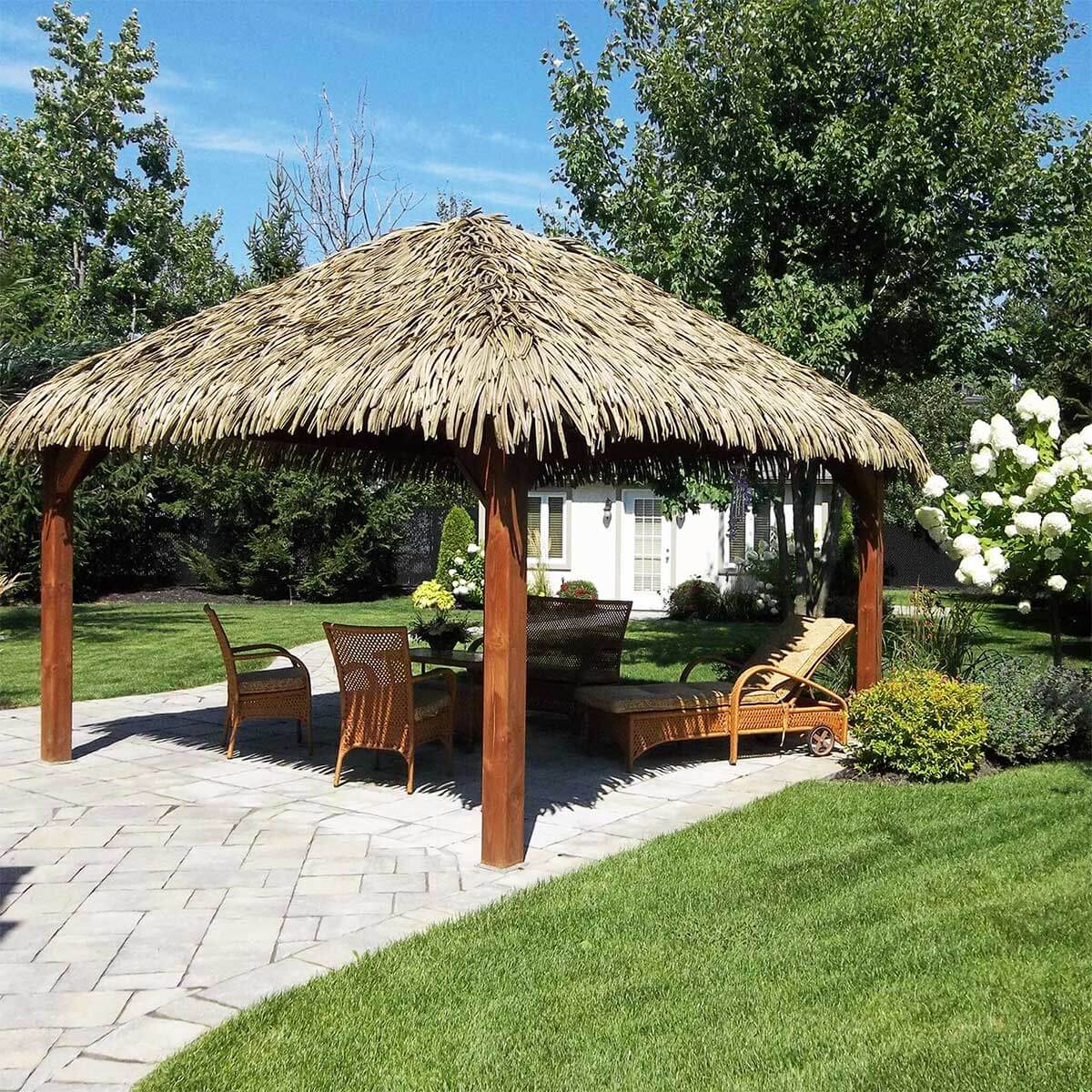Zone de détente sous une pergola en bois avec un recouvrement en chaume artificiel Palmita - Boutique Palmex