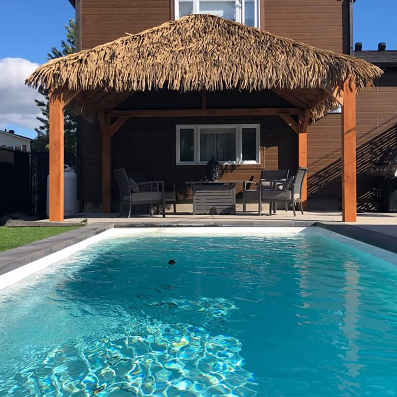 Pergola en bois avec un recouvrement en feuilles de palmier Palmita, sur le bord de la piscine - Boutique Palmex